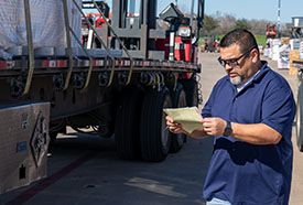 ABC employee looking at a piece of paper in front of a truck