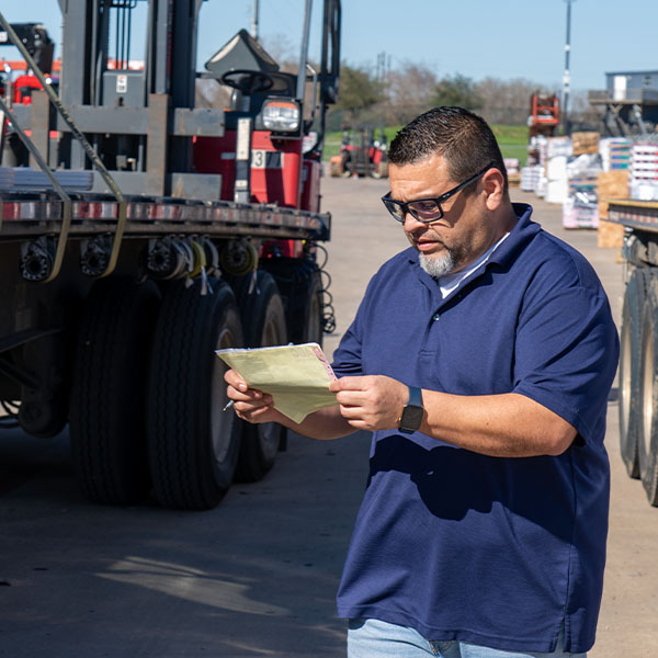 ABC employee looking at a piece of paper in front of a truck